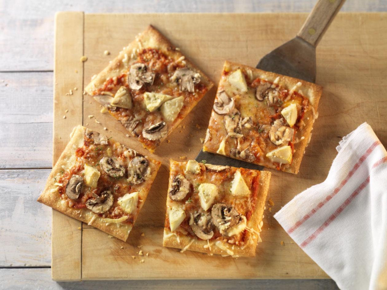 vegetarische pizza mit artischocken und champignons