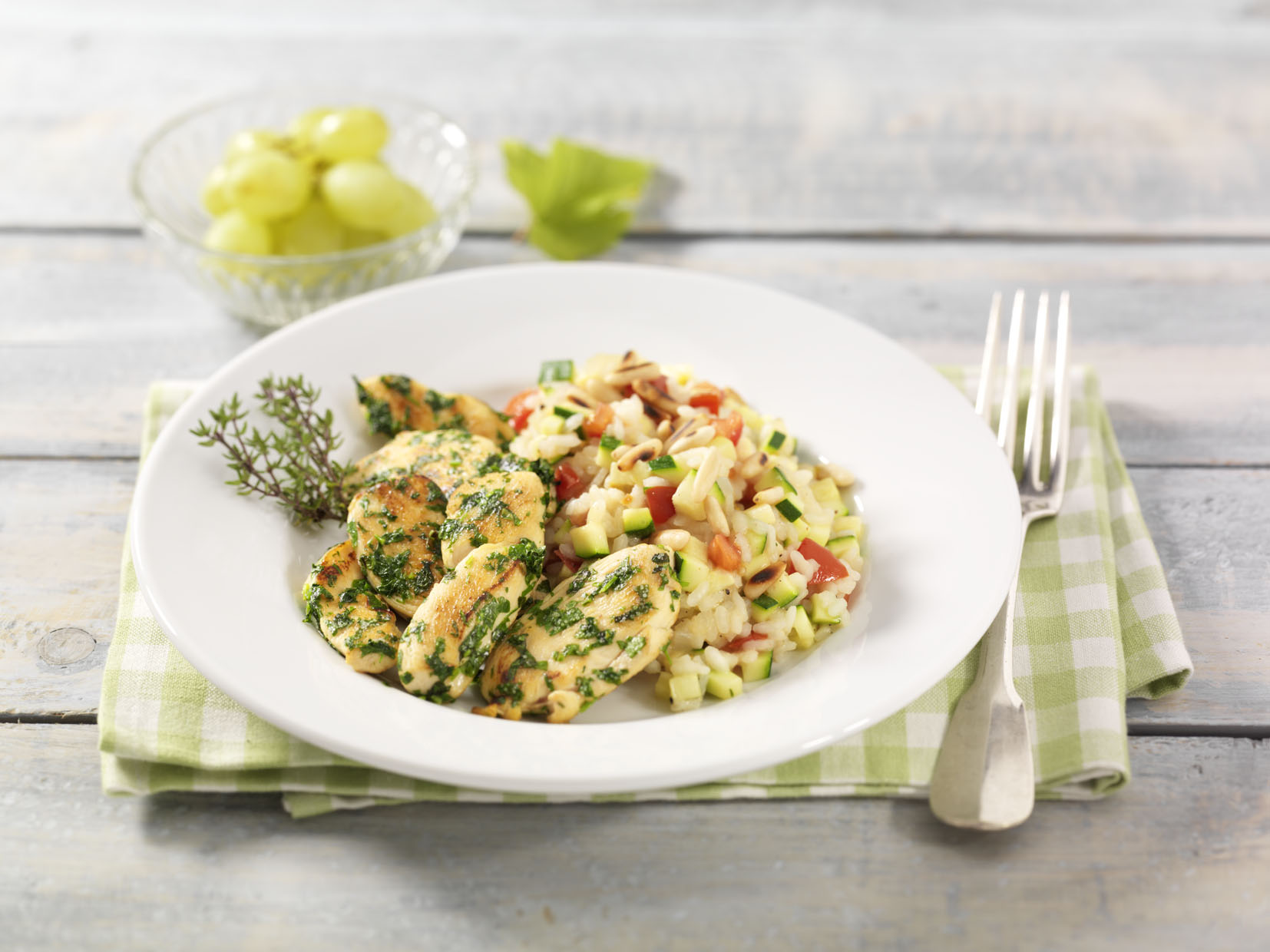 Kräuter-Pouletbrustfilets mit Zucchetti-Tomaten-Risotto und Pinienkernen